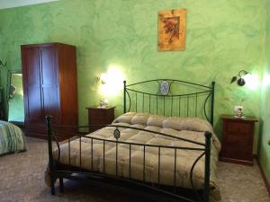 een slaapkamer met een bed in een kamer met groene muren bij Palazzo Aprile in Caltagirone