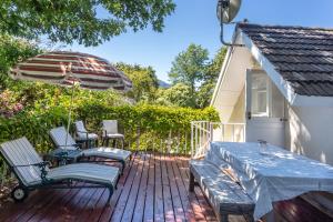 a patio with a table and chairs and an umbrella at Little House Villa in Cape Town