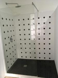a bathroom with a shower with black and white tiles at Bayerley in Plettenberg Bay +22 photos
