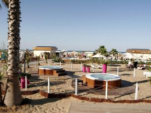 una spiaggia sabbiosa con due tavoli e una palma di Riccione Beachouse a Riccione