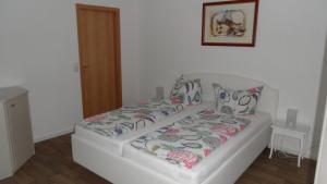 a small bedroom with a bed with a white bedspread at Ferienwohnung an der Therme in Bad Schandau