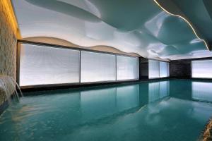 a swimming pool with blue water in a building at Olympic Residence Deluxe Apartments in Limassol