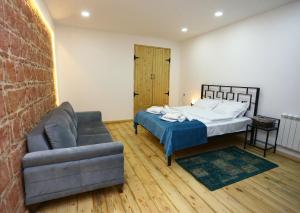 una sala de estar con una cama y un sofá en Tiflis Hut, en Tiflis