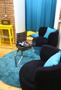 ein Wohnzimmer mit 2 Stühlen und einem Glastisch in der Unterkunft Tiflis Hut in Tbilisi City