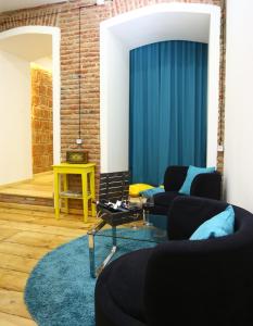 a living room with two couches and a blue curtain at Tiflis Hut in Tbilisi City