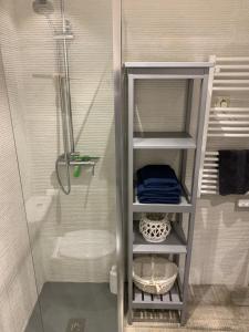 a bathroom with a shower and a shelf with towels at Golden Beach in Marbella