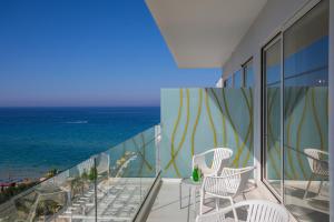 a balcony with chairs and a view of the ocean at Constantinos the Great Beach Hotel in Protaras