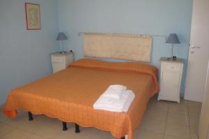 una camera con un letto con due comodini e due lampade di Il Palco residence a Cinquale