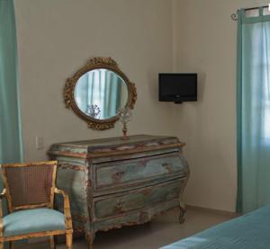 eine alte Kommode mit Spiegel und Stuhl in der Unterkunft Casa Madonna in Guadalajara