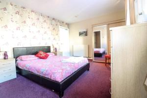 ein Schlafzimmer mit einem Bett mit einer rosa Decke in der Unterkunft The Bridge Inn in Tillicoultry