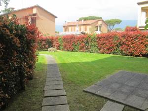 un jardin avec une passerelle en face d'une maison dans l'établissement Il Palco residence, à Cinquale