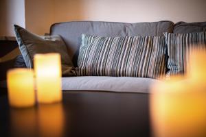 un sofá con almohadas y una mesa con dos velas encendidas en Villa Vinory - Tenuta il Sogno, en San Marzano Oliveto