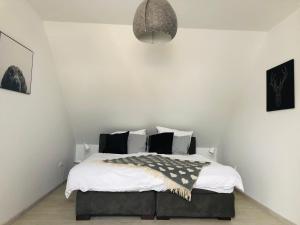 een slaapkamer met een bed met witte muren bij Ferienhaus Eifel Charlotte in Dahlem
