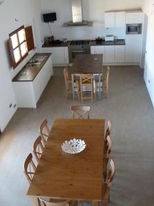 a kitchen and dining room with a wooden table and chairs at Casa S'Olibassa in La Mola