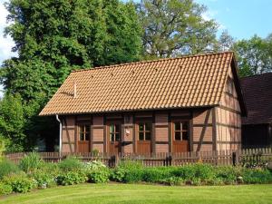 a small house with a wooden fence in a yard at Tödter in Soltau