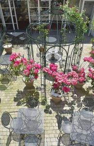 a patio area with tables, chairs, and flowers at Gradlon in Quimper