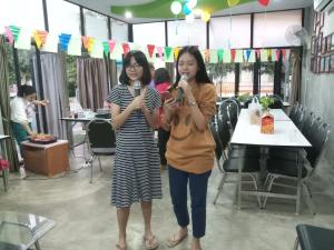 two women holding up microphones in a room at The luxury in Amphoe Sawang Daen Din
