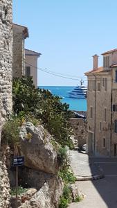 a street with buildings and the ocean in the background at la Tourraque in Antibes