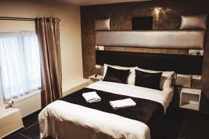 een slaapkamer met een groot bed en 2 handdoeken bij Hôtel onyx expo in Brussel