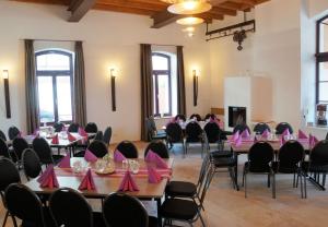 a room filled with tables and chairs with pink napkins at Storchenhof Teningen in Teningen