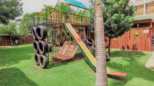 a playground in a yard next to a palm tree at Hoogland Spa Resort Bela Bela in Bela-Bela