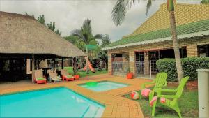 a house with a swimming pool with chairs and a playground at Hoogland Spa Resort Bela Bela in Bela-Bela