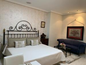 Un dormitorio con una cama grande y una silla azul. en La Sierra, en Antequera