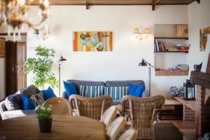 uma sala de estar com um sofá, uma mesa e cadeiras em Villa Vinory - La Mandragola em Mombercelli