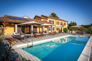 a swimming pool in front of a house at Villa Vinory - La Mandragola in Mombercelli