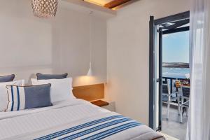 a bedroom with a bed and a view of the ocean at Parian Boutique Hotel in Naousa