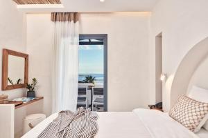 a bedroom with a bed and a view of the ocean at Parian Boutique Hotel in Naousa