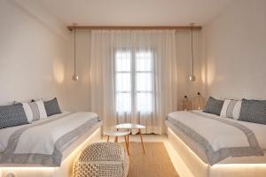 a white room with two beds and a window at Parian Boutique Hotel in Naousa