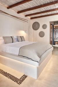 a white bedroom with a large white bed at Parian Boutique Hotel in Naousa