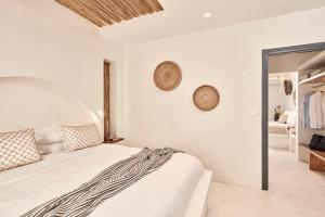 a white bedroom with a bed and a sliding glass door at Parian Boutique Hotel in Naousa