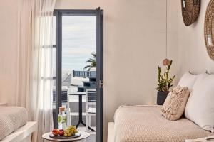 a bedroom with a bed and a table with a plate of fruit at Parian Boutique Hotel in Naousa