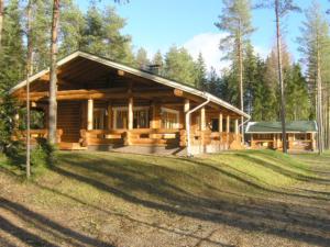una gran cabaña de madera en el bosque con un gran patio en Holiday Home Kivitasku by Interhome, en Kallionkieli