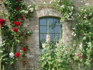 una finestra su un muro di mattoni con fiori di Ferienwohnungen im Bauernhaus _ Ob a Papendorf