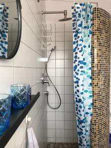 a bathroom with a shower with a blue and white shower curtain at Viktória Inn Tihany in Tihany +120 photos