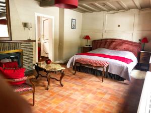 ein Schlafzimmer mit einem Bett und einem Kamin in der Unterkunft Hostellerie de la Chapelle in Malmedy