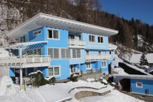 un edificio azul en la nieve en Appartementhaus Lercher, en Flattach