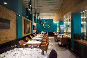 a dining room with tables and chairs and blue walls at Vanilla Garden Boutique Hotel - Adults Only in Playa de las Americas