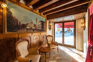 威尼斯的住宿－Hotel Scandinavia - Relais，一间设有两把椅子的房间和墙上的一幅画