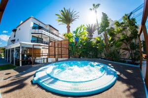 a large pool in front of a house at Vanilla Garden Boutique Hotel - Adults Only in Playa de las Americas