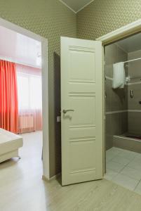 ヴォログダにあるGuest house Sosediのバスルーム(シャワー、白いドア付)
