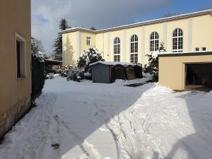 a driveway covered in snow in front of a building at Ferienwohnung am Rathaus in Heidenau