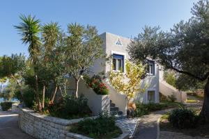 a white house with trees in front of a street at Into The Blue Villa in rkadiko Chorio