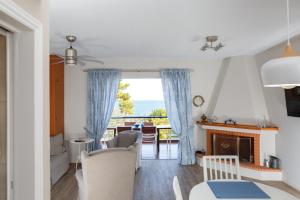 a living room with a fireplace and a view of the ocean at Into The Blue Villa in rkadiko Chorio