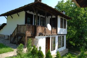 a house with a porch and a balcony at Къща Балканец in Balkanets