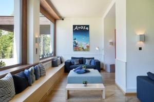 a living room with blue couches and a table at Hotel Seehof-Arosa in Arosa +81 photos