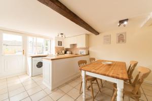 a kitchen with a table and chairs in a room at Mill View in Northleach